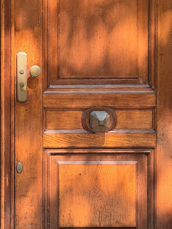 Detail of the oak front door with brass doorknob and fittings