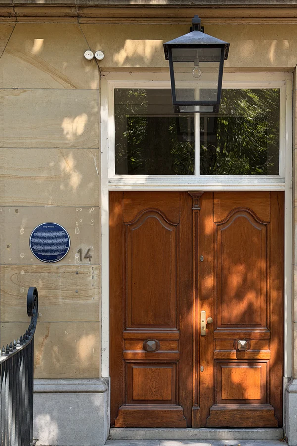 The monumental entrance with wooden double door, fanlight and lantern